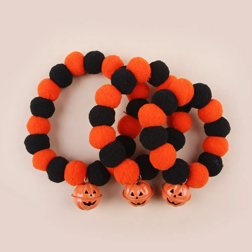 Orange Halloween cat collar with a pumpkin graphic and text, showing the adjustable clasp.
