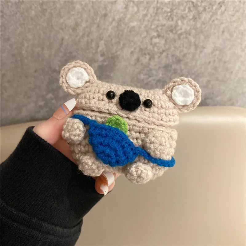 Handmade knitted koala bear backpack-shaped cover for an AirPods charging case.