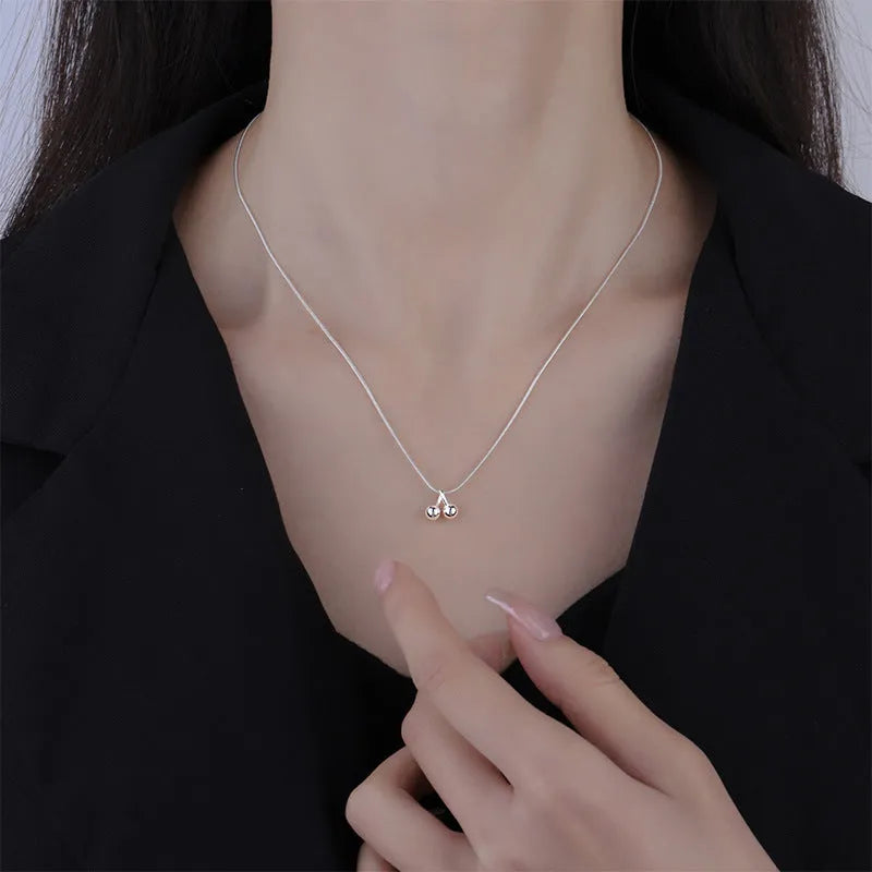 S925 sterling silver adjustable cherry pendant necklace with a snake bones chain on a white background.