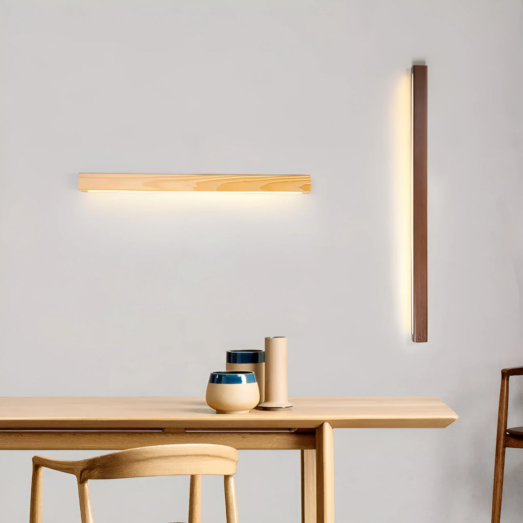 Modern walnut-coloured log strip wall lamp in three sizes on a white wall.
