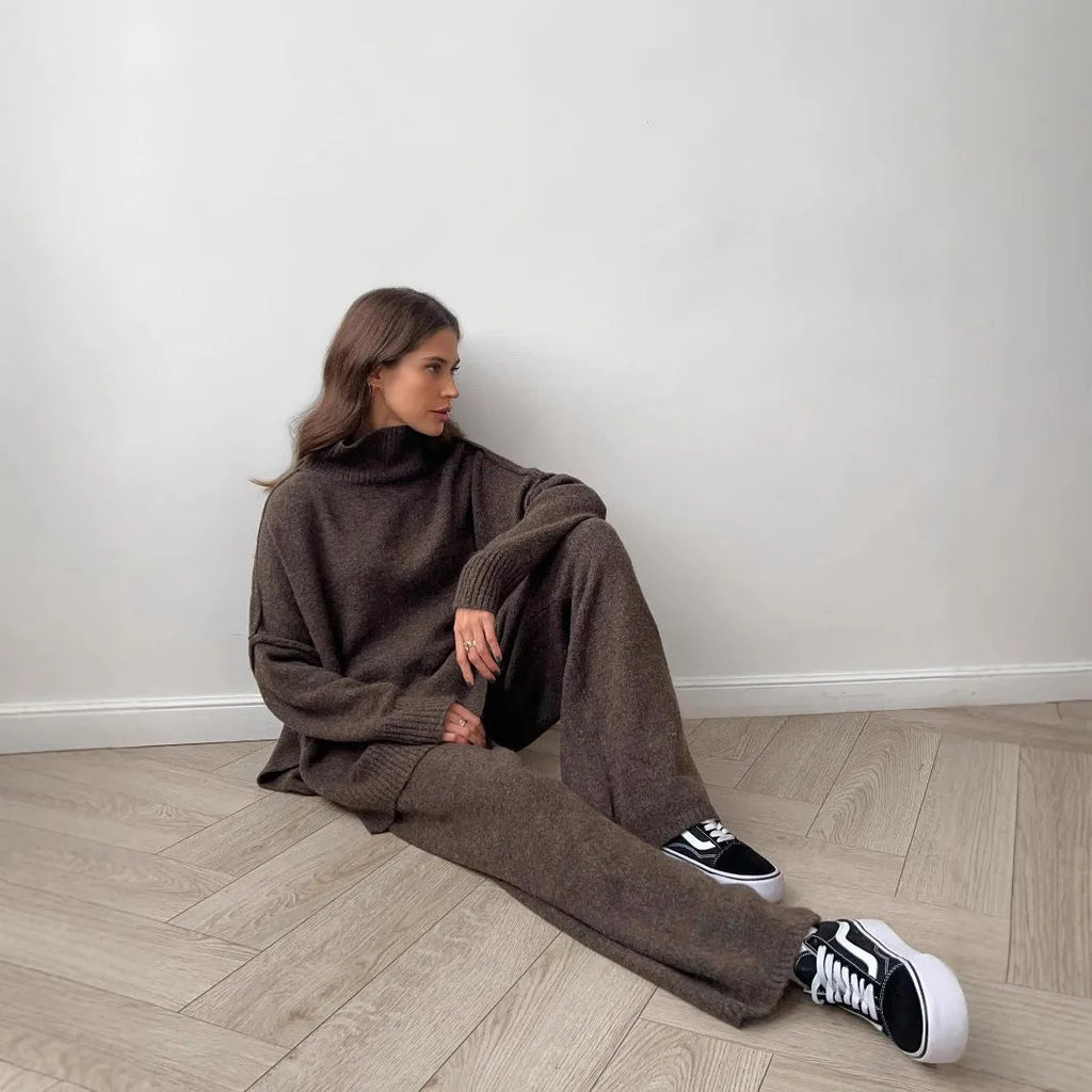 Women's dark grey side-slit knit top and matching trousers, a two-piece acrylic suit set laid flat.