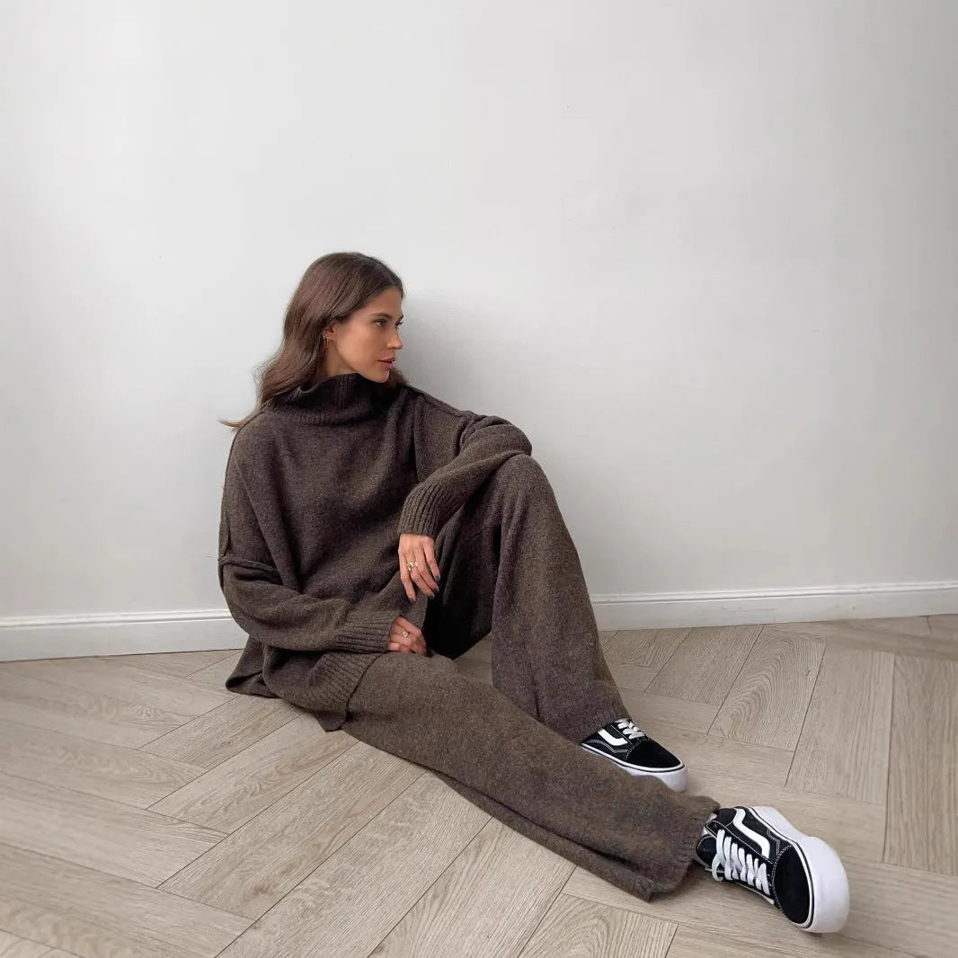 Women's dark grey side-slit knit top and matching trousers, a two-piece acrylic suit set laid flat.