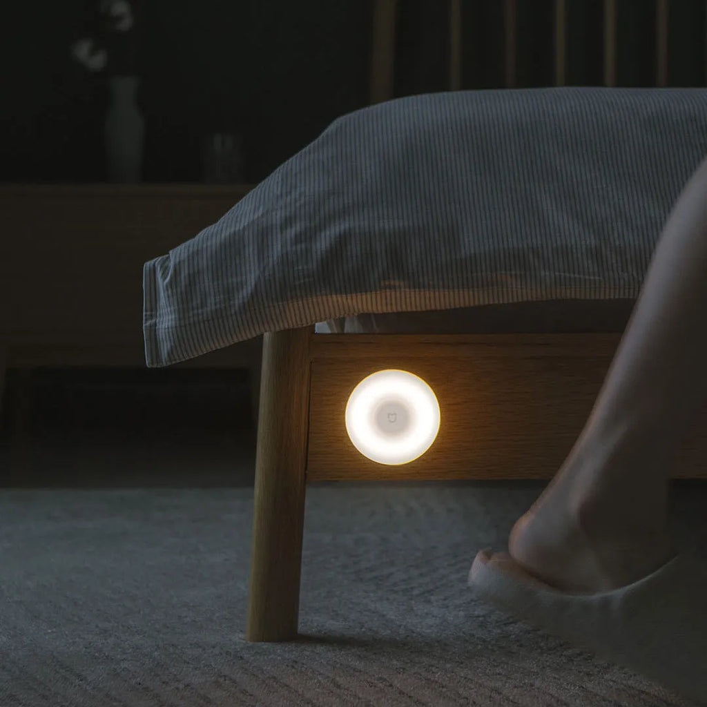 White Mijia Bluetooth bedside table lamp with human body induction on a wooden surface