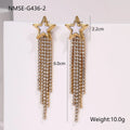 Close-up of a pair of gold plated stainless steel earrings featuring a heart shape design with diamond tassel and geometric star details.