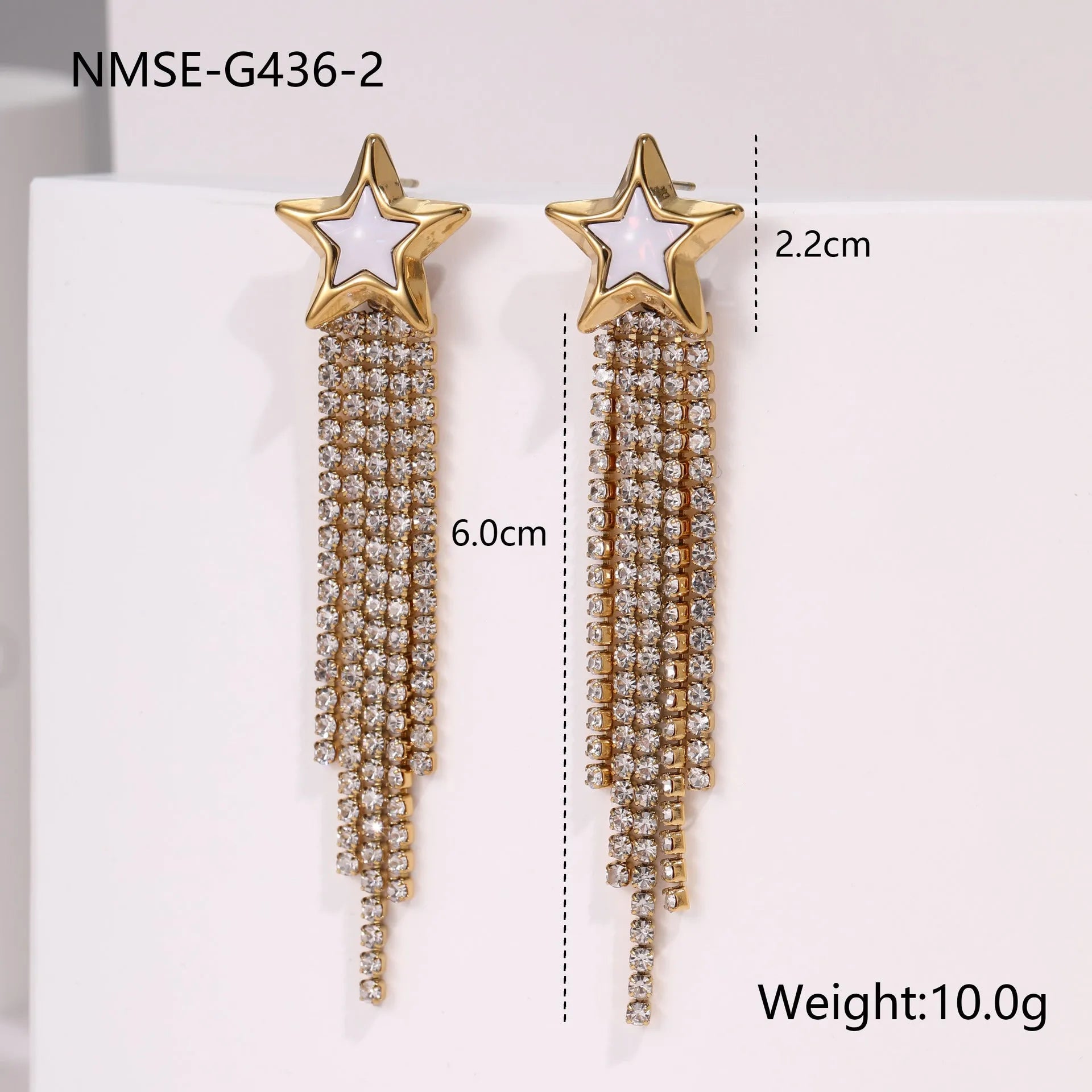 Close-up of a pair of gold plated stainless steel earrings featuring a heart shape design with diamond tassel and geometric star details.