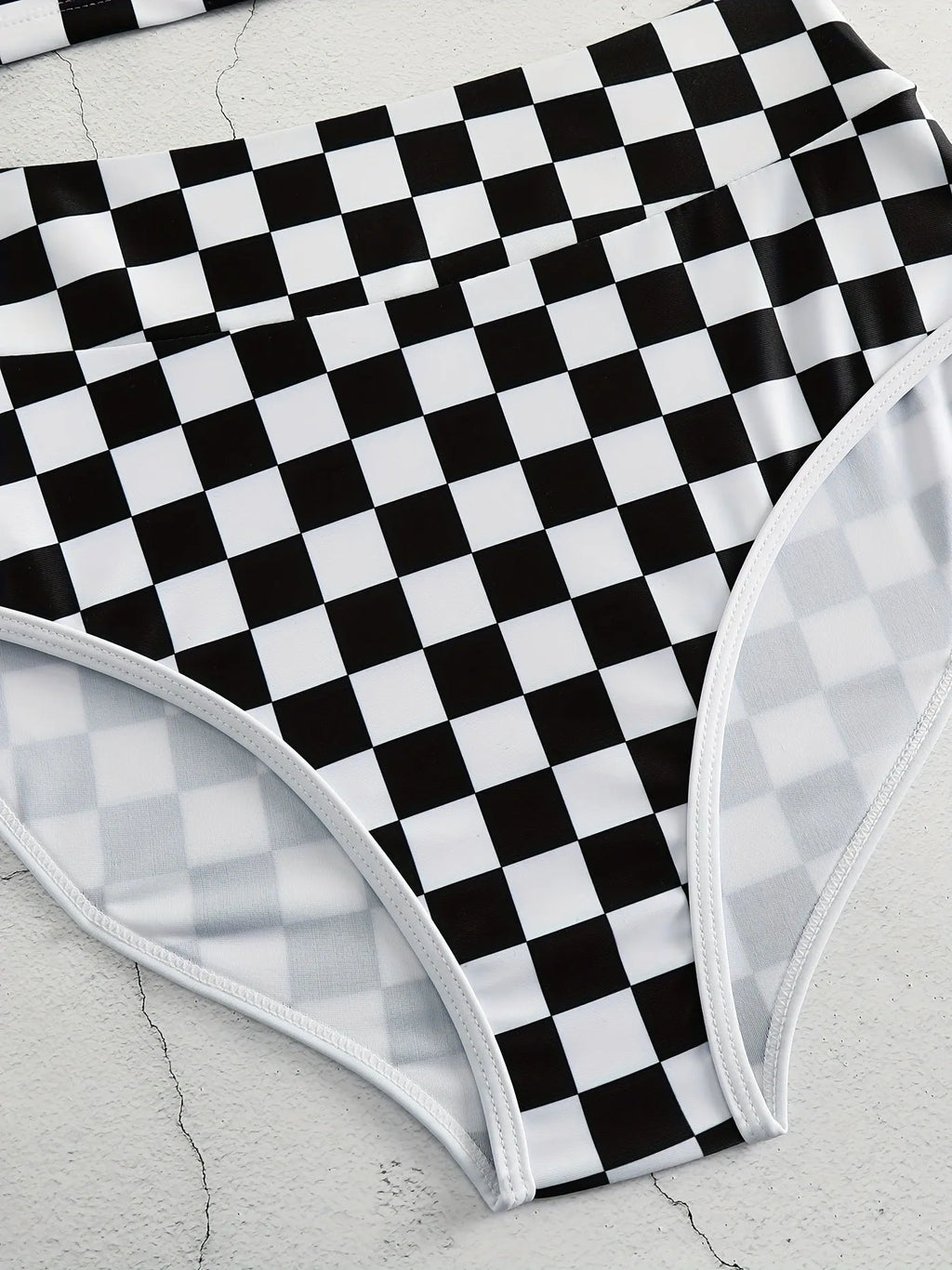 Women's backless racing swimsuit with shoulder suspender strap in black and white chessboard pattern