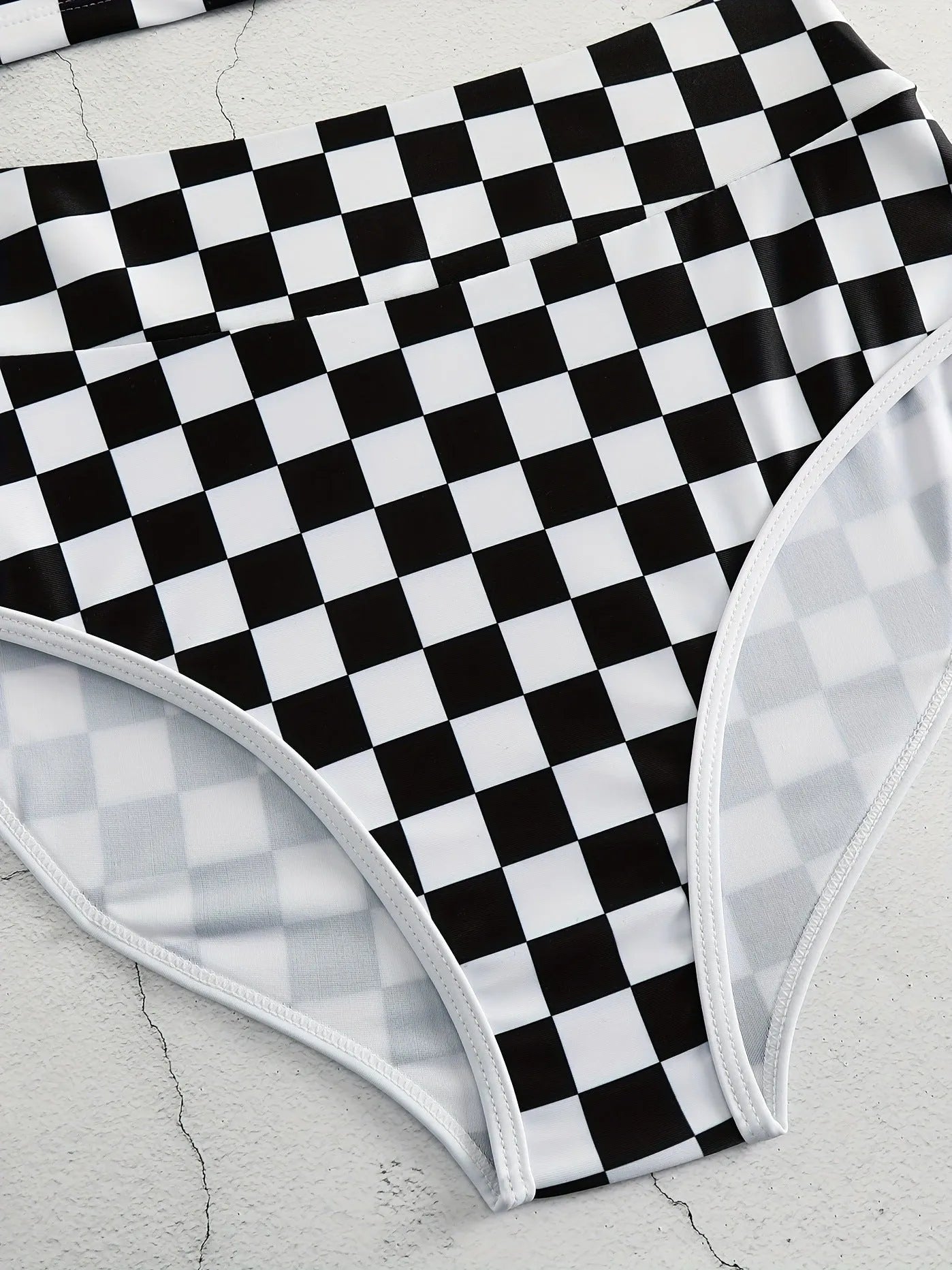 Women's backless racing swimsuit with shoulder suspender strap in black and white chessboard pattern