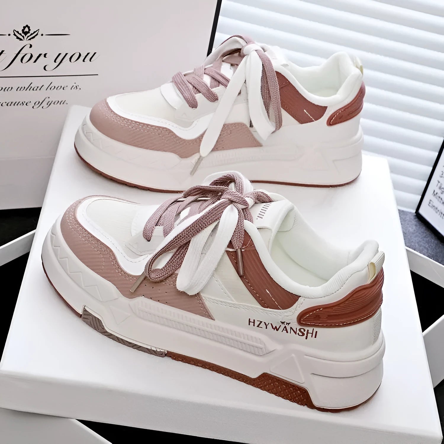 Beige children's lace-up trainers with cross straps over instep and thick rubber sole.