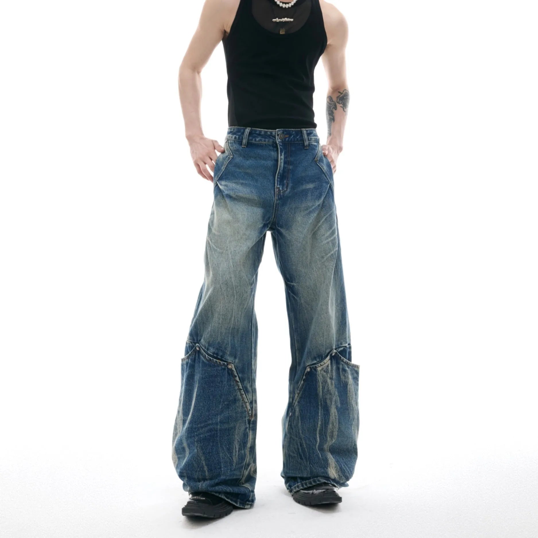 Man wearing verdant blue loose-fit jeans with a curved knife burst pattern on the thighs.