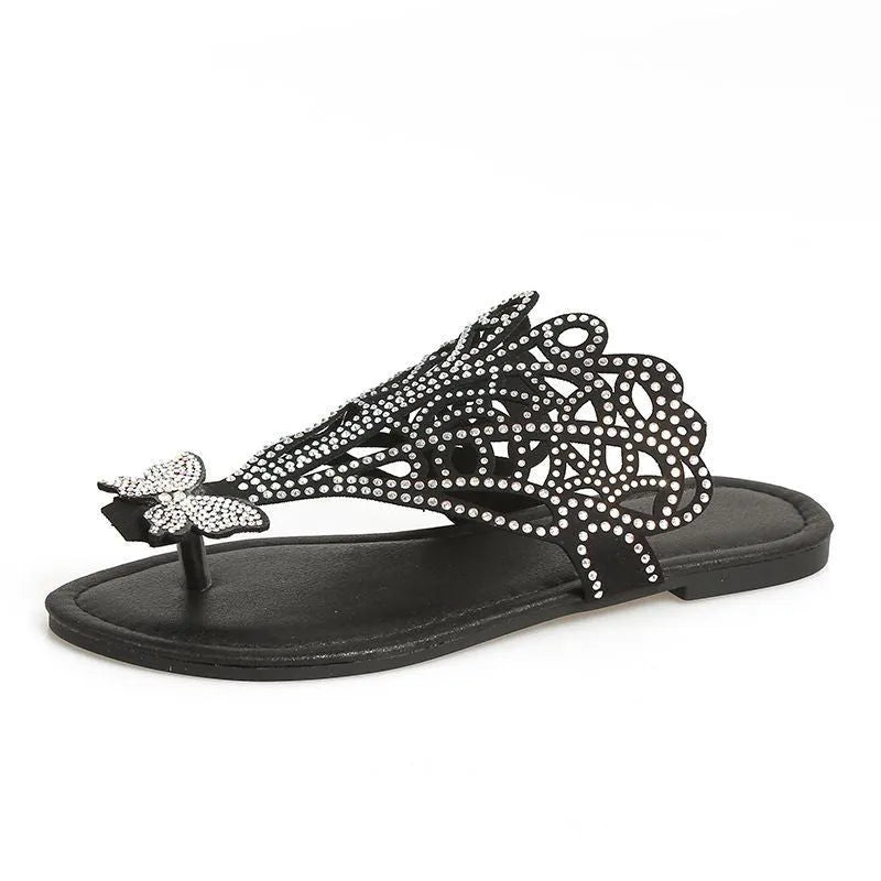 Women's black slip-on sandals with rhinestone decoration on a flip-toe, hollowed slipper design.