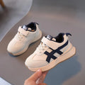 Children's white velcro sneakers with synthetic leather upper and rubber sole on a neutral background.