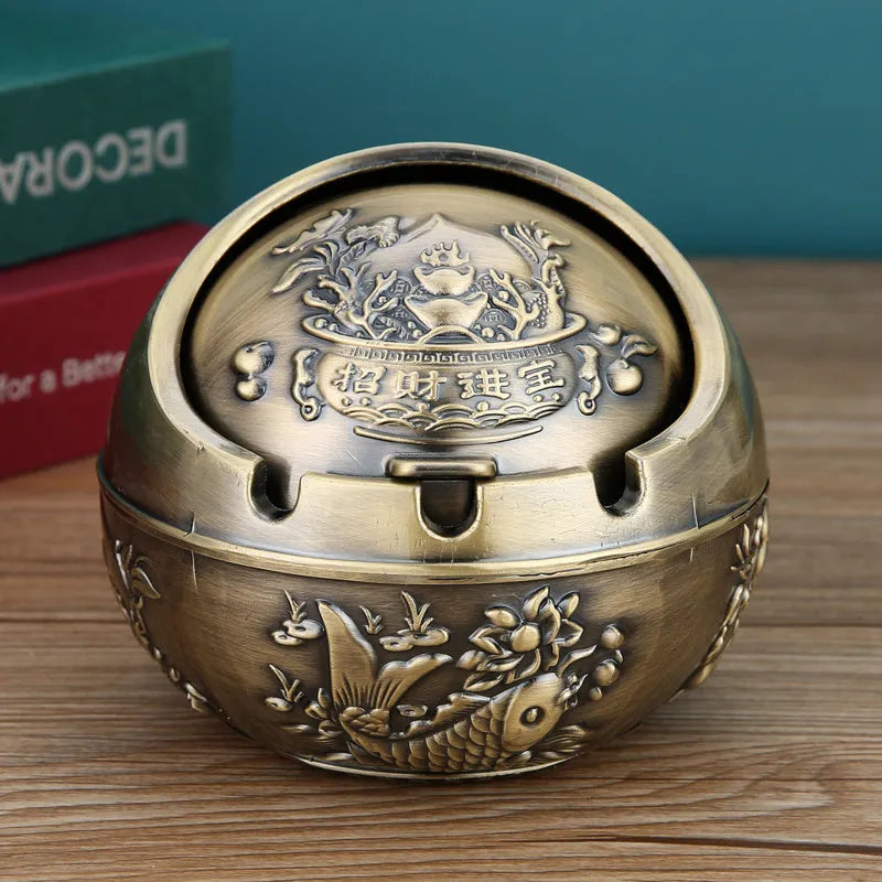 Alloy decorative ashtray in bronze with ornate peacock motif and cigarette extinguishing slot.