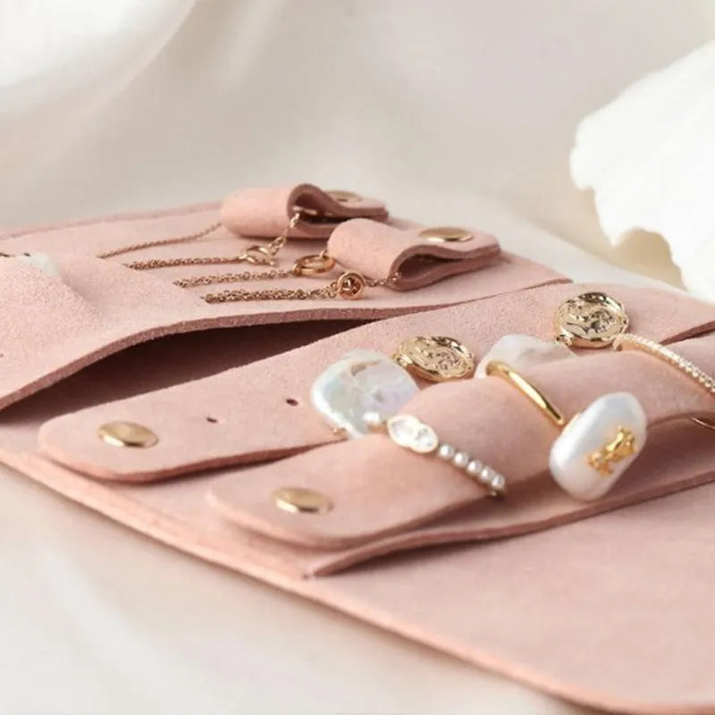 Brown PU leather jewellery storage pouch open to show microfiber lining, with earrings and a ring inside.
