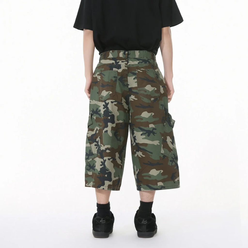 Man wearing loose camouflage print cotton jeans with wide legs and side stitching.