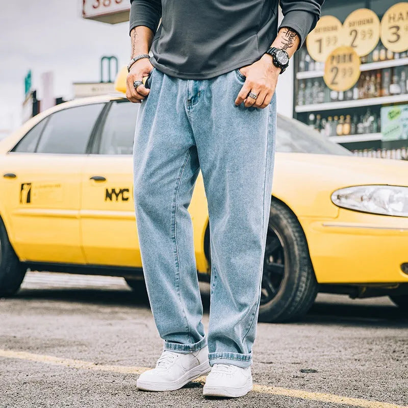 Men's dark blue loose straight-leg cotton jeans on a hanger, showing the simple style and mid-waist fit.