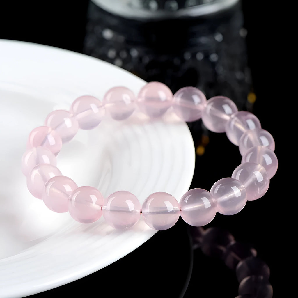 Natural crystal round bead bracelet with polished starlight effect in pink colour, showing bead detail and sizing options