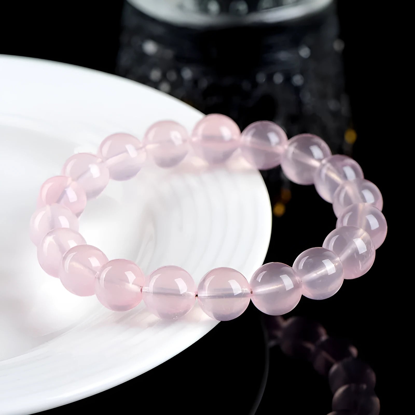 Natural crystal round bead bracelet with polished starlight effect in pink colour, showing bead detail and sizing options