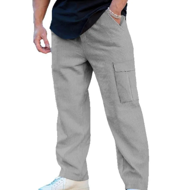 Men's loose-fitting corduroy cargo trousers in a brick red colour with a wide-leg silhouette.
