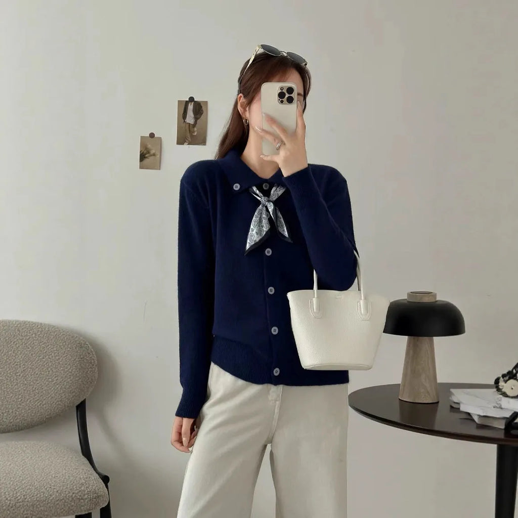 Milky white cardigan sweater with a lapel scarf collar and spliced knit detailing.