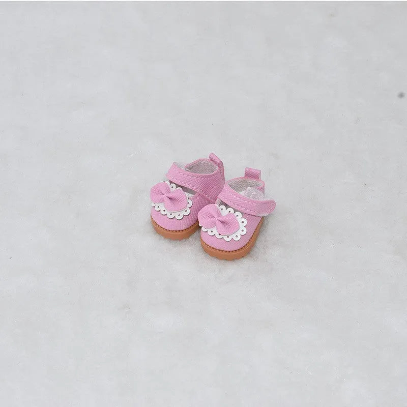 Pair of miniature black boots for a 17cm fashion doll on a white background.