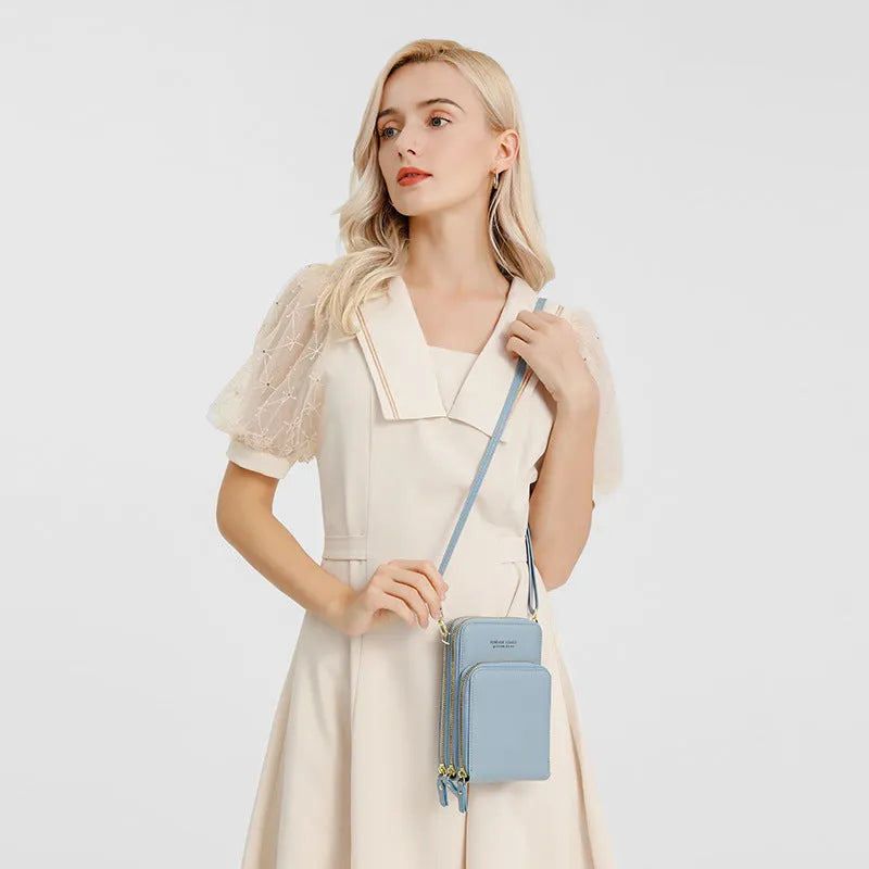 Green crossbody bag with tri-fold pockets and zipper closure on white background