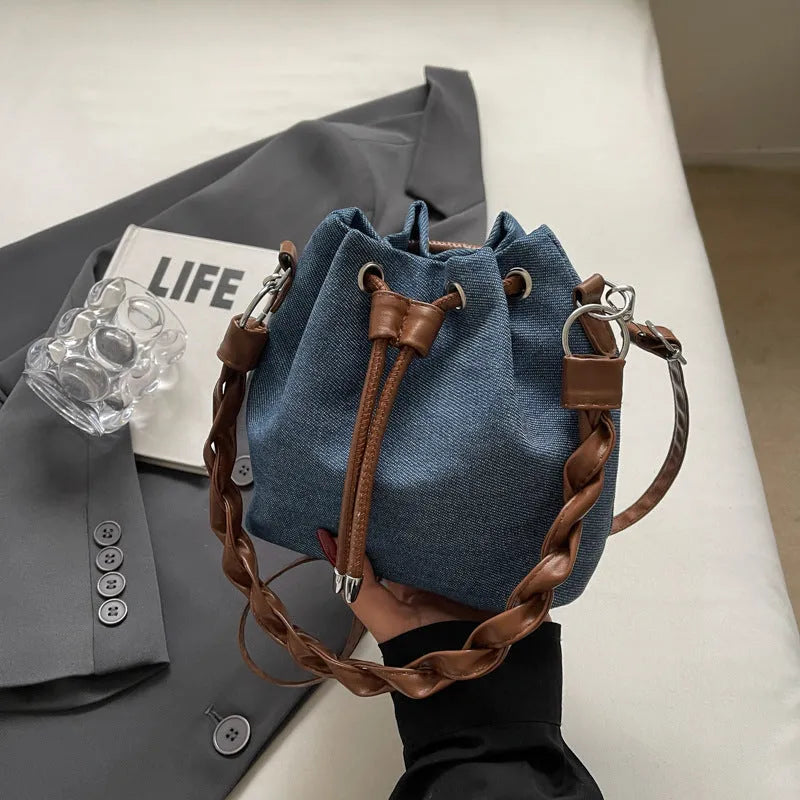 Blue one-shoulder cross body bucket bag with sandwich pocket design and messenger styling