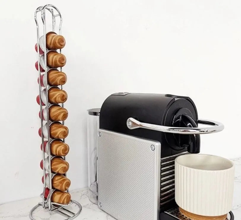 Black wrought iron coffee capsule storage rack holding pods on a kitchen counter.