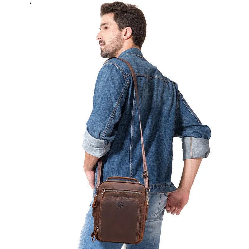 Men's brown Crazy Horse leather crossbody bag with visible sewing lines and adjustable shoulder strap