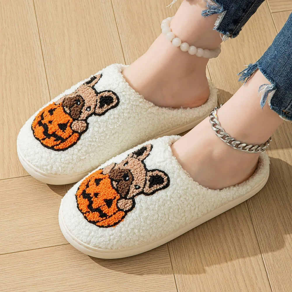 Black and white Halloween plush slippers with pumpkin design, round toe, and textured non-slip TPR soles.