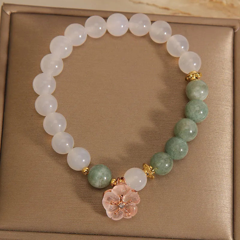 White agate floral bracelet with jade details and adjustable clasp on woman's wrist