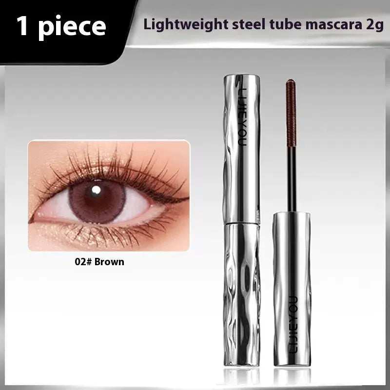 Black waterproof mascara in a steel tube, shown with an eyelash curler option.