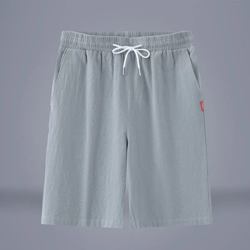 Man wearing loose-fit cotton linen cropped trousers in army green with a drawstring waist.