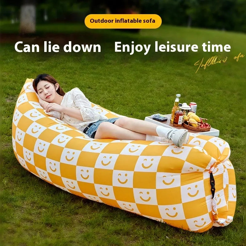 Yellow smiling face tip inflatable portable outdoor sofa seat on grass