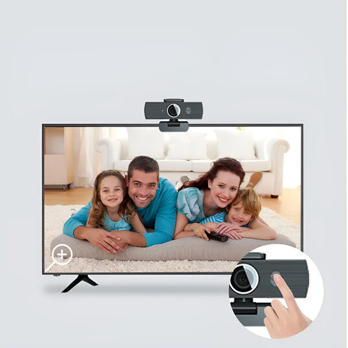 Black USB webcam with magnetic privacy cover on a desktop next to a laptop.