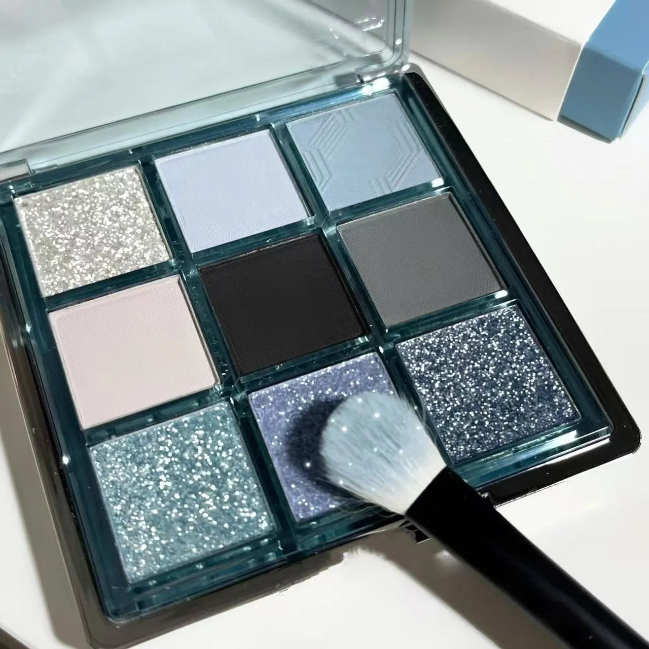 MUGELEEN nine-colour eye shadow palette showing matte and shimmer finishes in low saturation tones