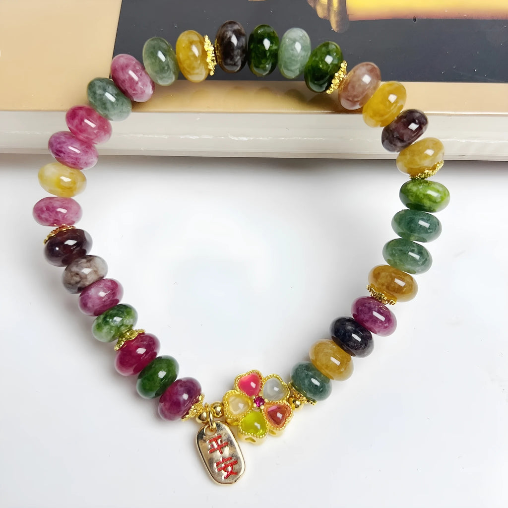 Women's bracelet with colourful tourmaline abacus beads and artificial crystal on wrist.