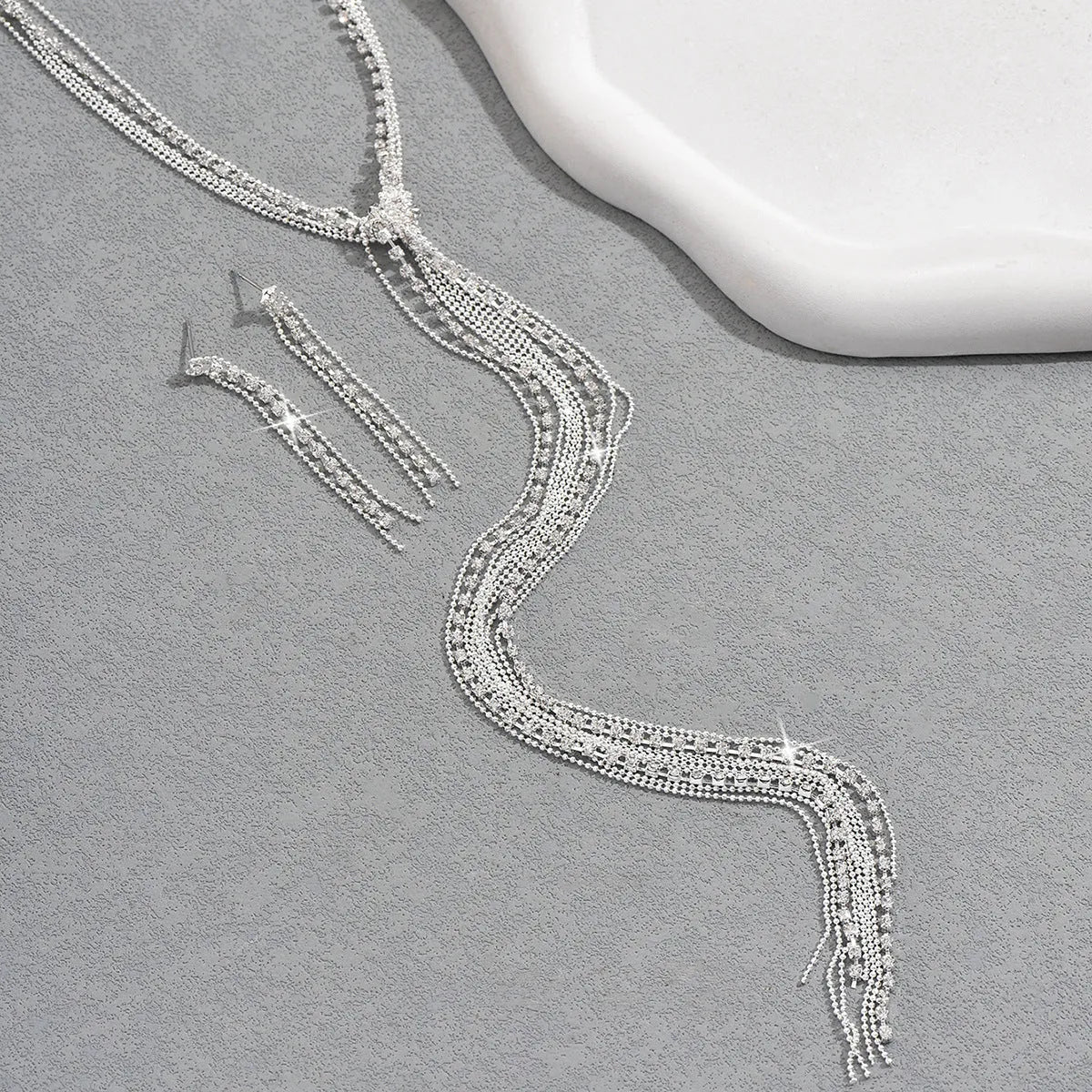 Silver curb chain necklace with rhinestone pendant and matching long earrings in a three-piece set for women