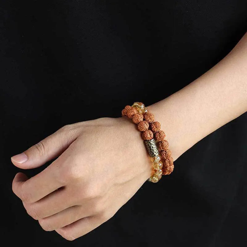 Handmade yellow tower crystal bracelet with double ring design on wrist.