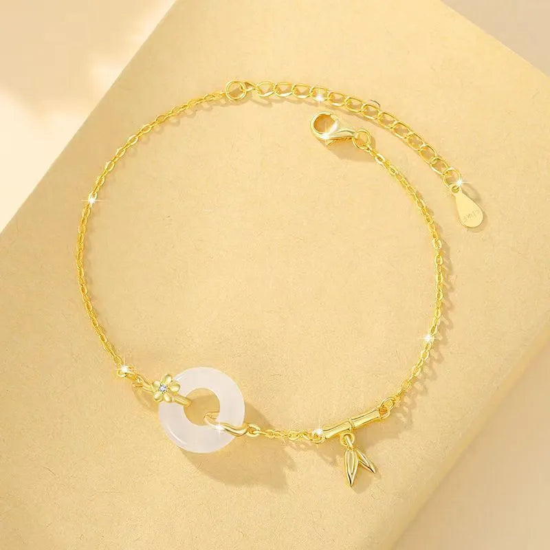 Silver gold electroplated women's bracelet with a white chalcedony stone and prominent peace buckle clasp on a 22 cm band.