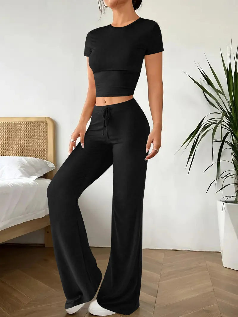 Black women's polyester trousers suit with high-waist trousers and a short-sleeve T-shirt on a hanger.