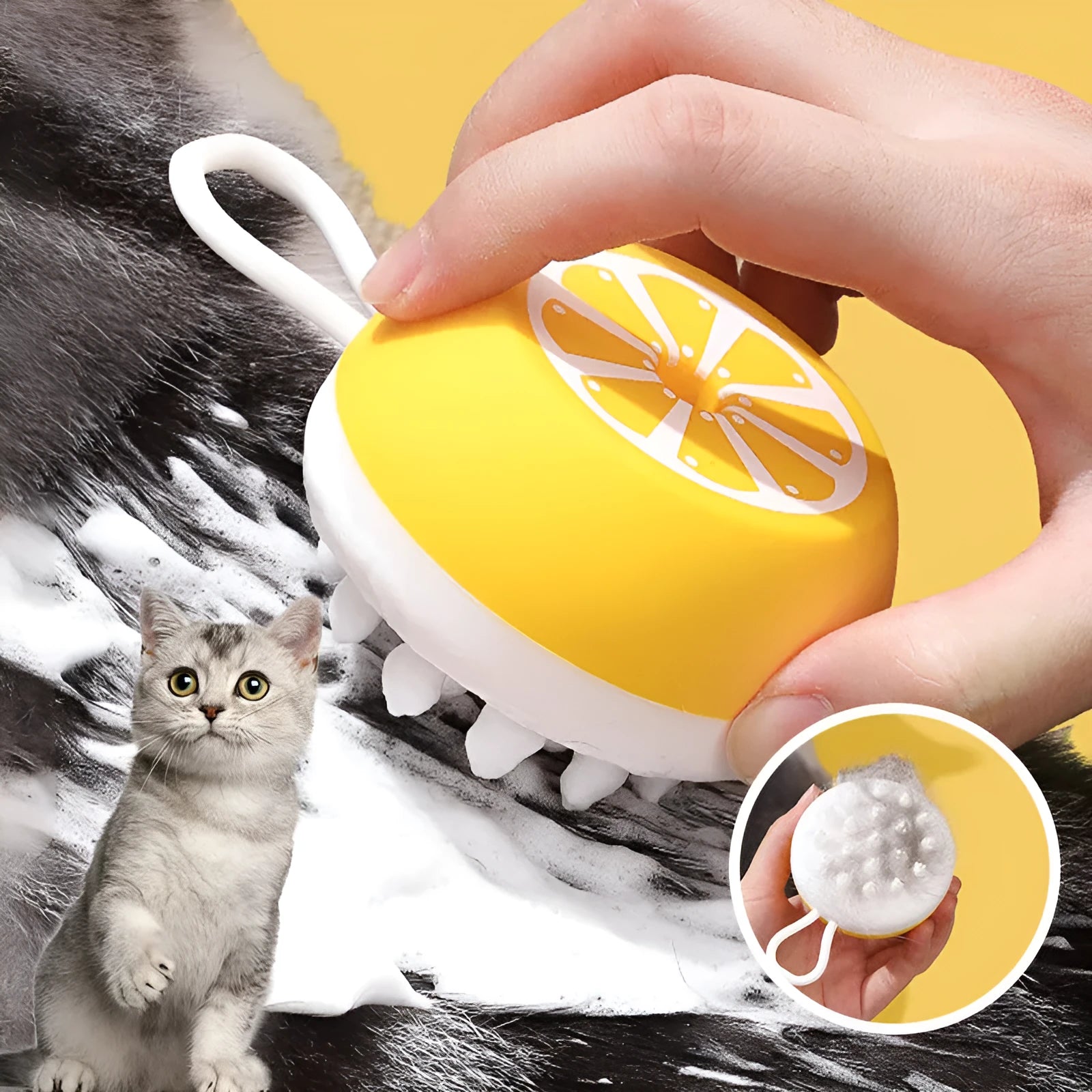 Yellow silicone pet bath brush and grooming comb tool held in a hand.