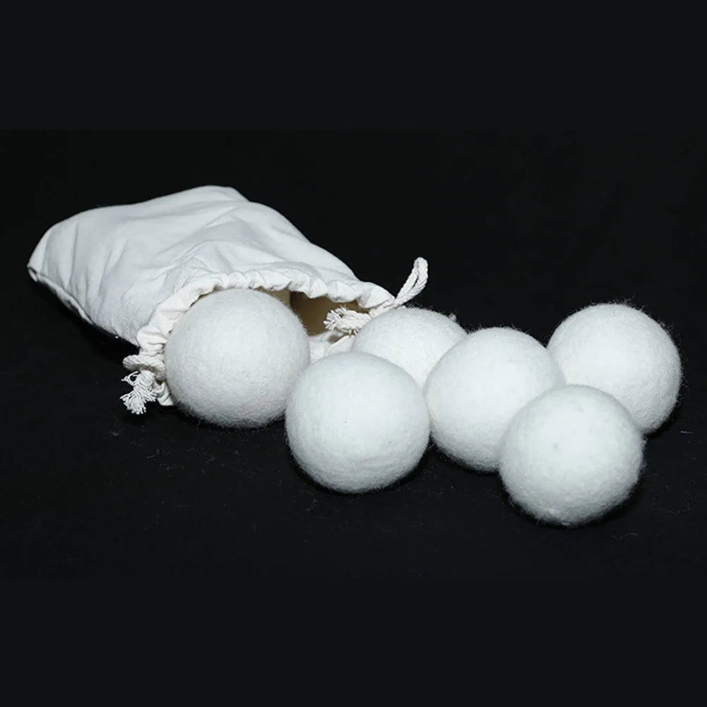 Set of 100% wool felt laundry drying balls in various sizes next to a plain cotton storage bag.