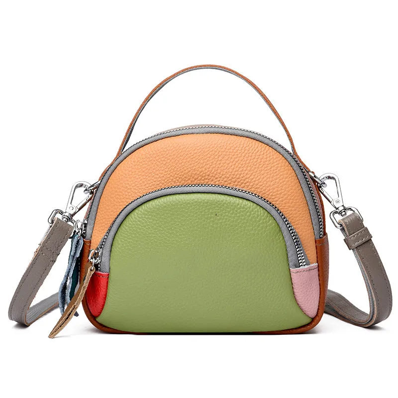 Round hand-held crossbody bag made from first layer cowhide leather with visible sewing line detail on exterior
