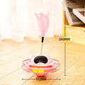 Pink cat tumbler turntable toy with feather attachments on rotation platform