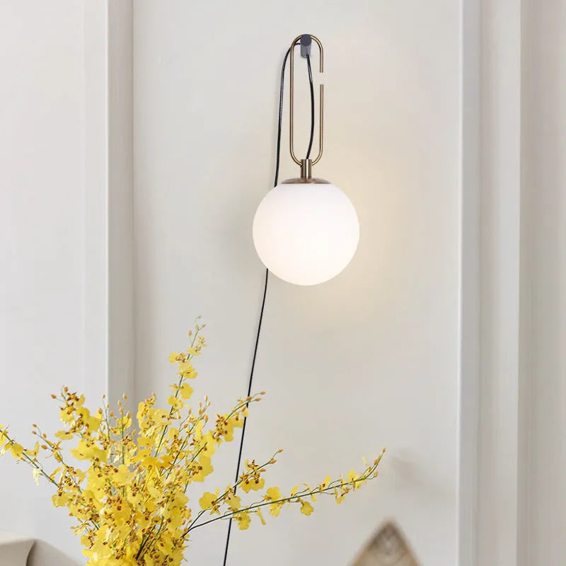 Nordic modern glass wall lamp on a white wall displaying warm white light.