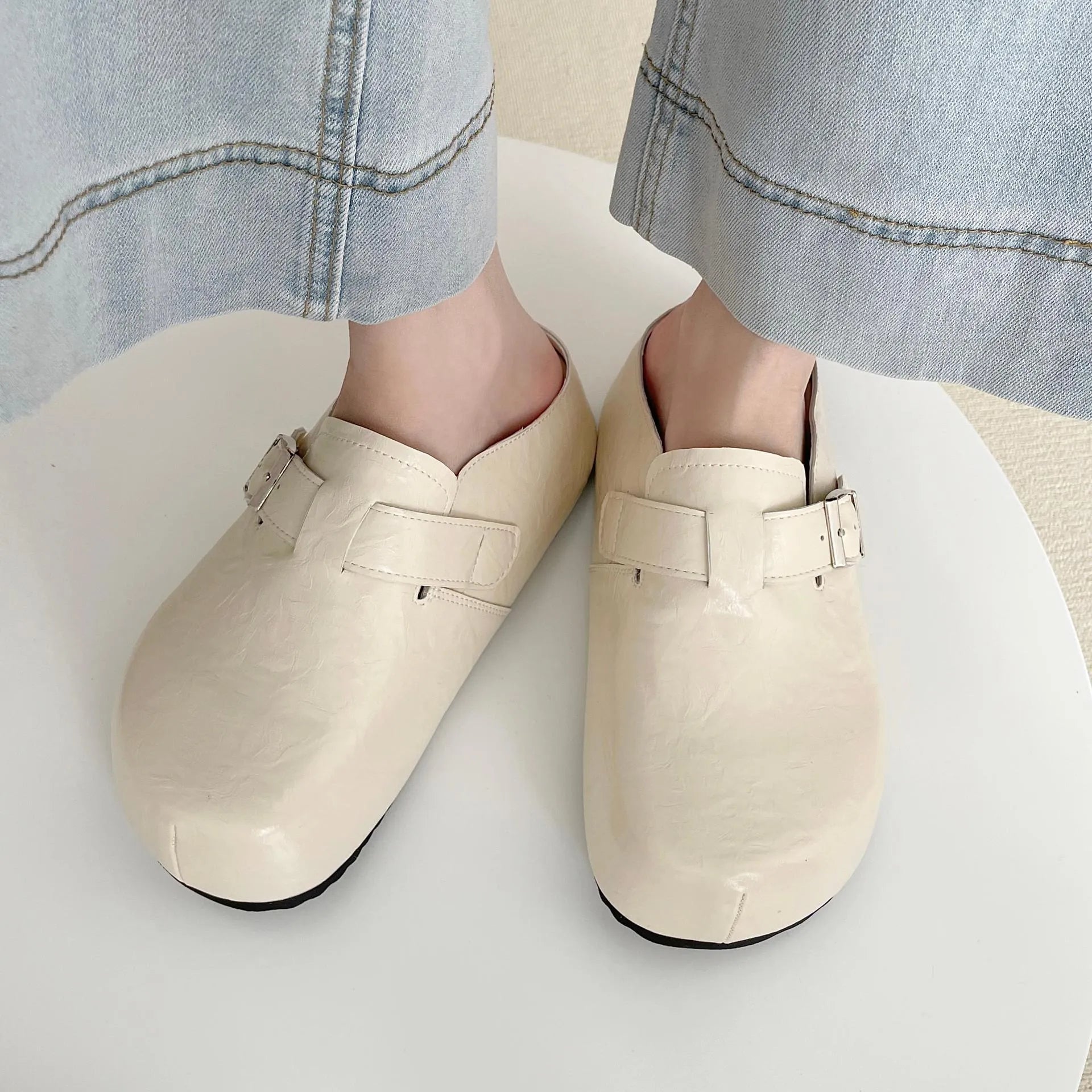 Flat buckle casual sneakers in yellow, creamy-white, silver, and black colours with round toe.