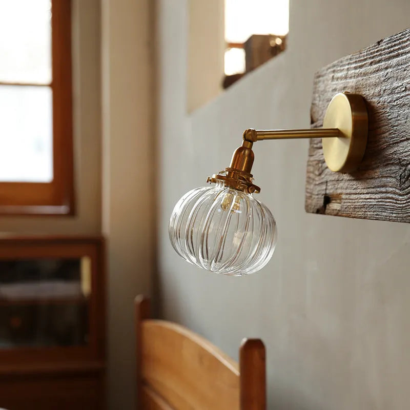 Creative pumpkin-shaped wall lamp with hand-blown water ripple glass shade mounted on a brushed nickel bracket.