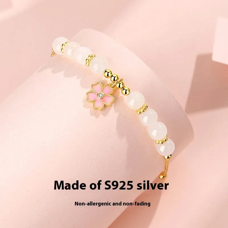 Pink women's bracelet with silver chain, Hetian jade beads, and a detailed cherry blossom flower pendant.
