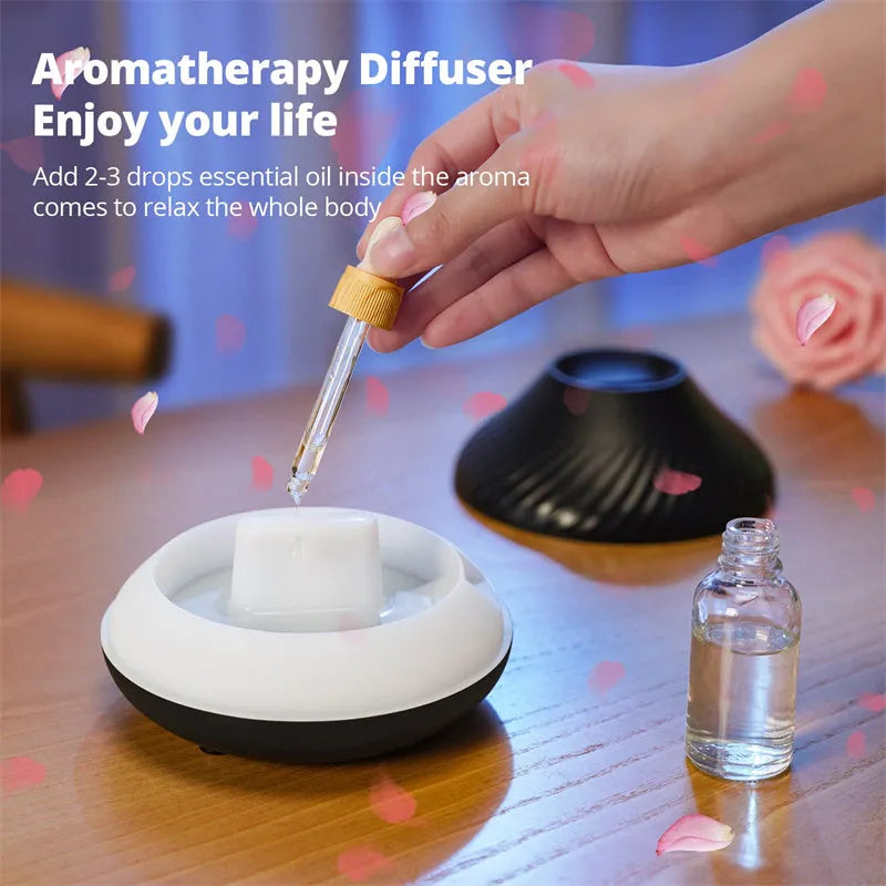 Beige volcanic flame aroma diffuser with LED light on a wooden table next to an essential oil bottle