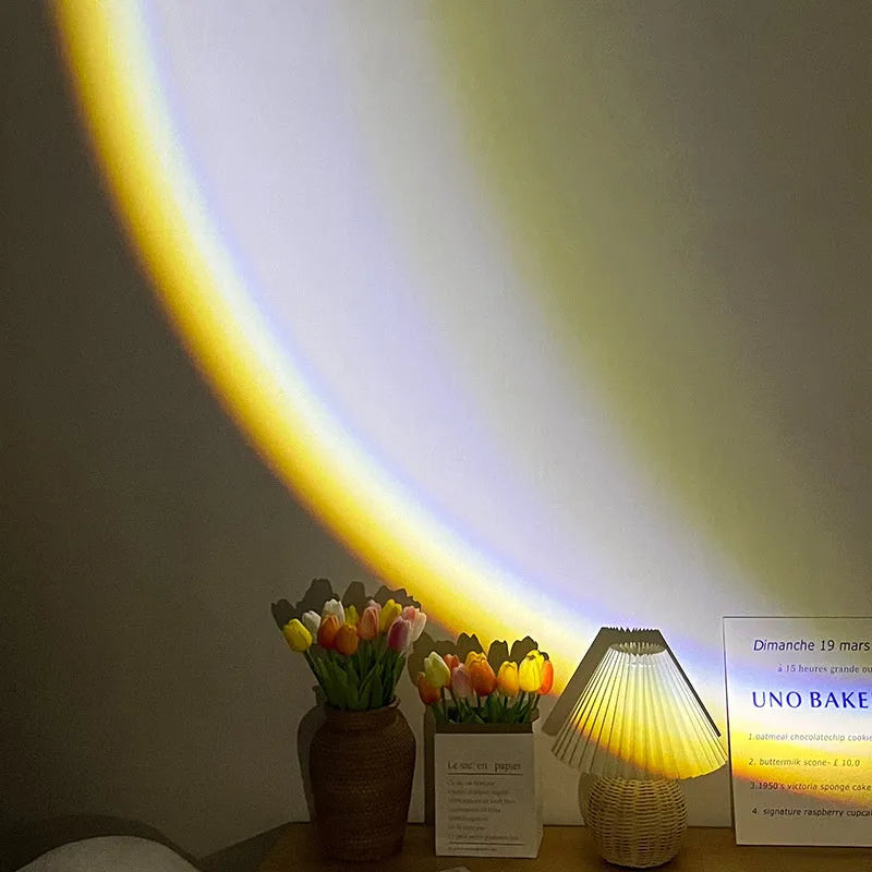 INS USB Moon Lamp LED projector on a table projecting rainbow light onto a wall.